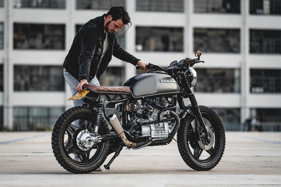 Man standing next to a custom Honda cafe racer motorcycle in Eindhoven.