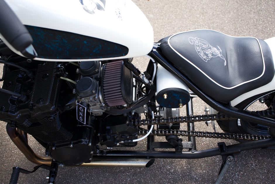 Detailed view of a custom motorcycle's engine and stylish saddle, perfect for biking enthusiasts.